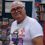 Photograph of Lou Zocchi, a large white man, balding with grey hair, wearing dark rimmed glasses and a t-shirt.